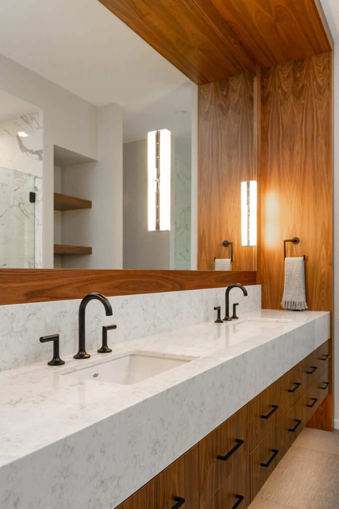Primary ensuite with walnut vanity, marble shower, walnut shelves and sightline to tub