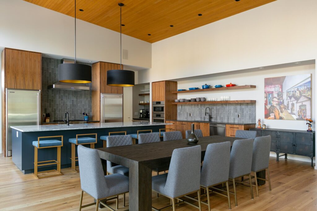 Dining and kitchen with vaulted cedar ceiling, blue island, walnut cabinets and pop art