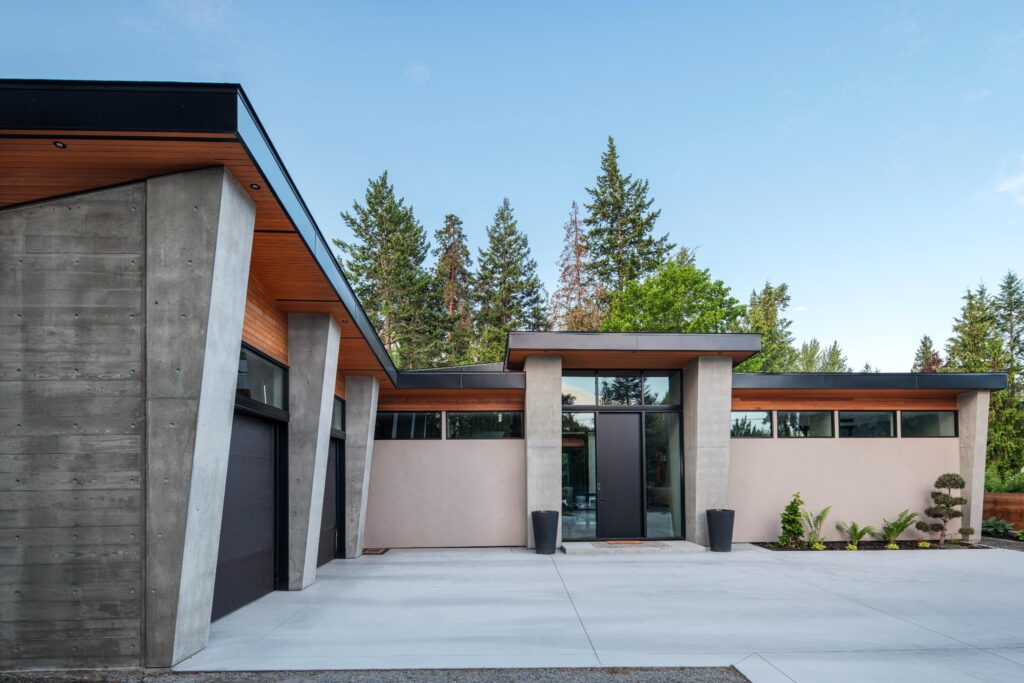 Modern single-level Kelowna rancher with board-formed concrete, cedar soffits and flat rooflines