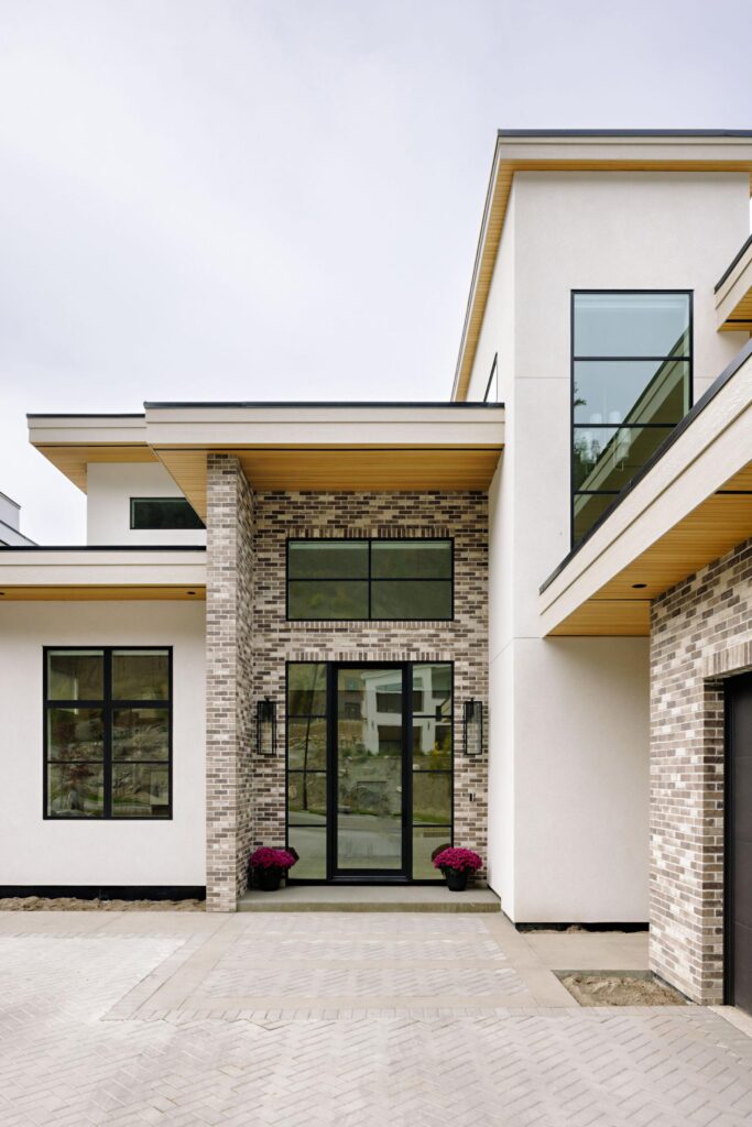 Modern Kelowna custom home entry with brick, white stucco, cedar soffits and flat rooflines