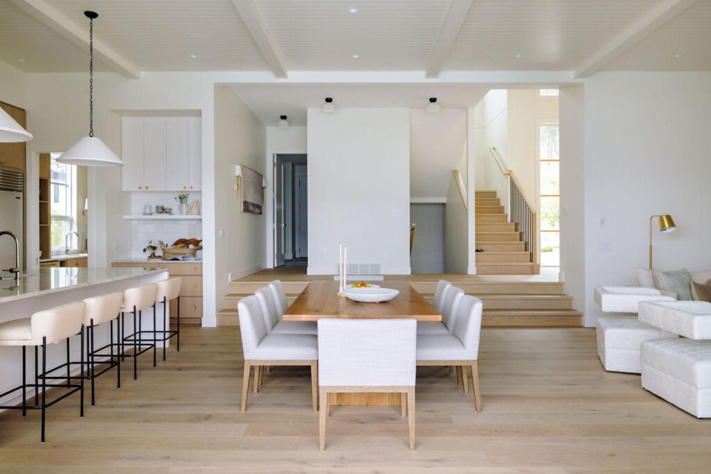 Open concept dining, kitchen and split-level staircase with coffered ceiling and oak floors
