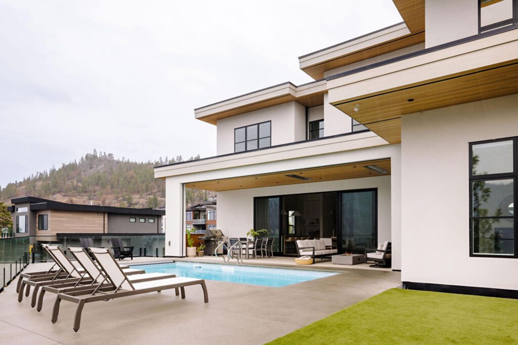 Modern hillside home with pool deck, cedar soffits and Okanagan mountain views