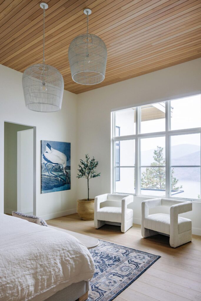 Primary bedroom with vaulted cedar ceiling, woven pendants and lake views
