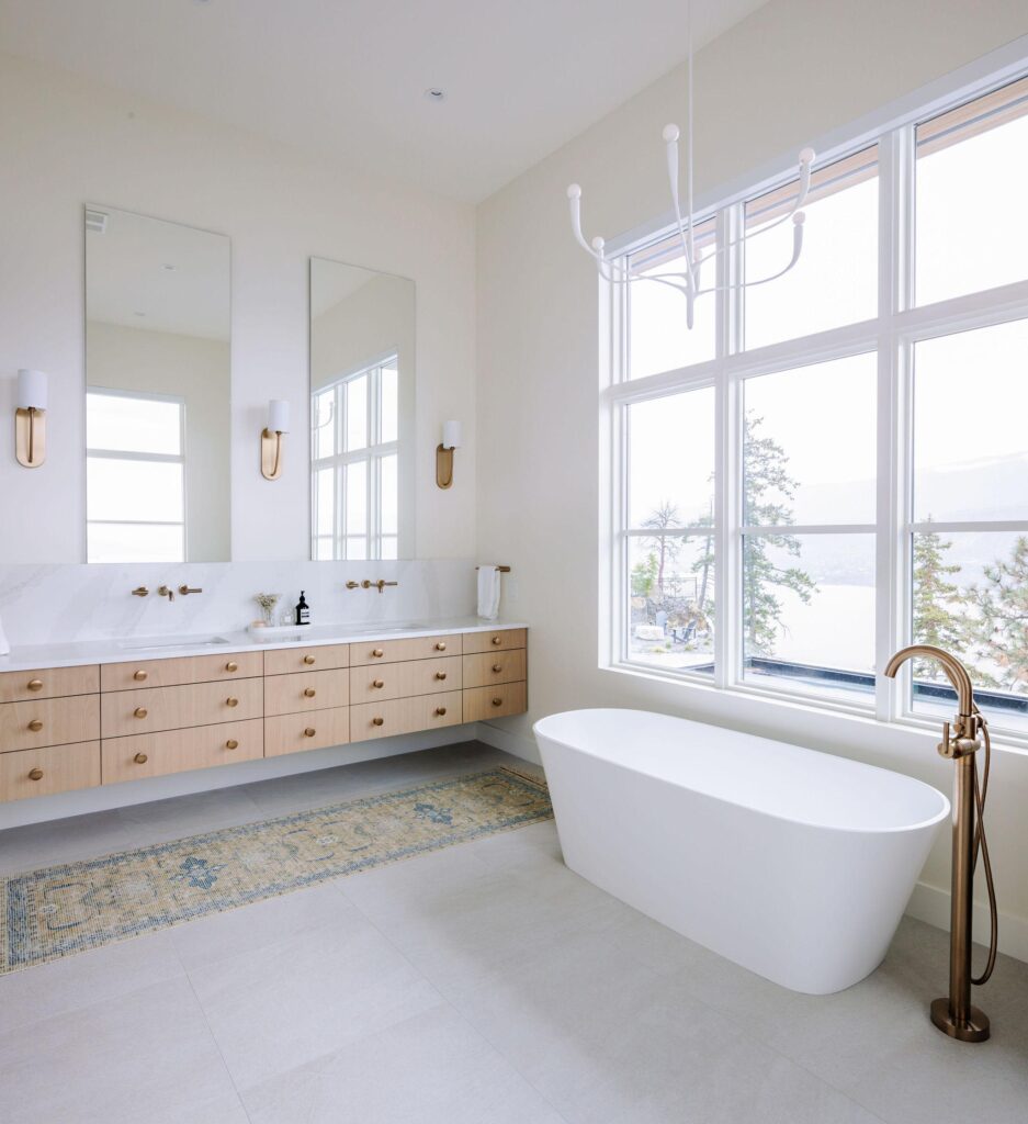 Spa-like primary ensuite with freestanding tub, floating oak vanity and Okanagan Lake views