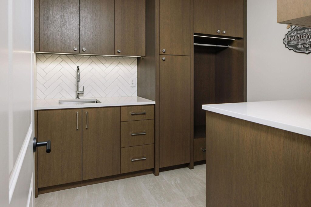 Custom laundry room with dark oak cabinetry, herringbone tile and hanging rod