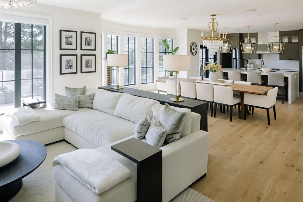 Open concept dining and kitchen with brass chandelier, live-edge table and grey cabinetry