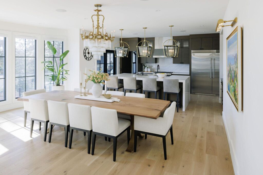 Open concept living room with cream sectional, black-framed windows and brass accents