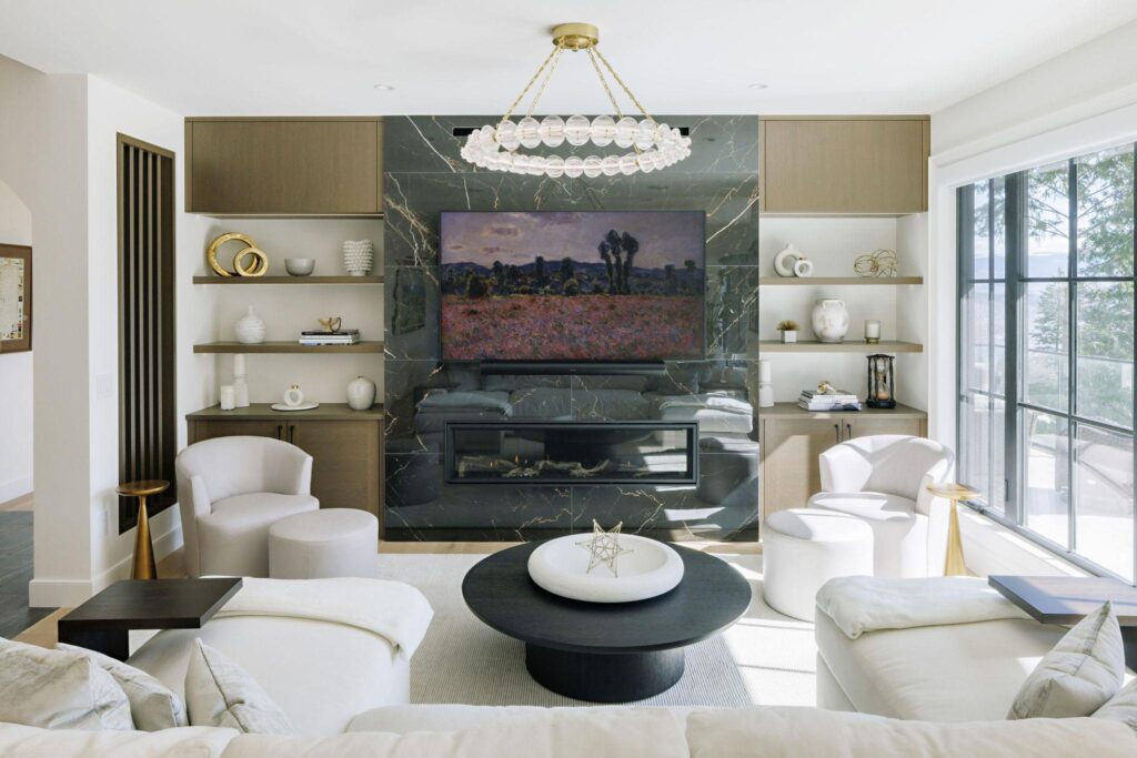 Luxury living room with green marble fireplace, bubble chandelier and white slipcovered seating